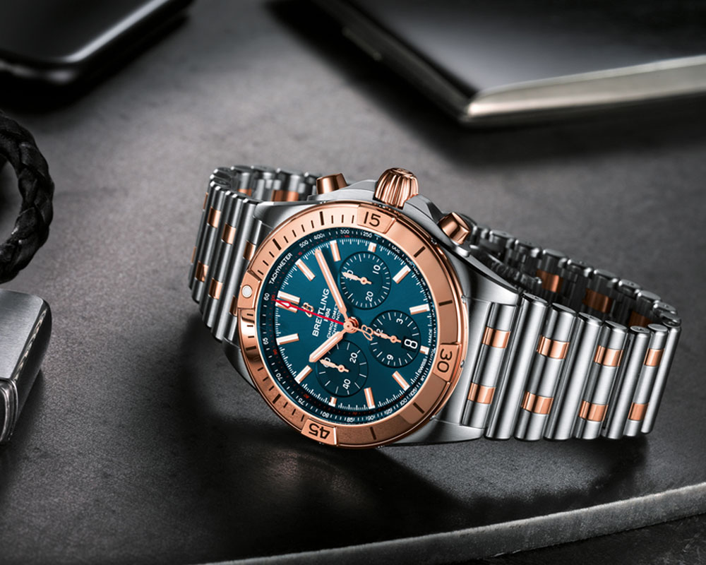 16 two tone chronomat b01 42 with a blue dial and tone on tone chronograph counters highlighted by an 18 k red gold bezel crown and pushers