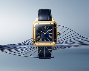 The new Santos-Dumont watch in yellow gold case with beaded crown set with a synthetic blue cabochon-shaped spinel, and a blue sunray-finish dial.
